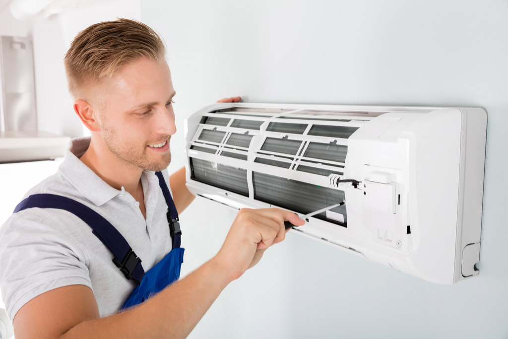HVAC technician cleaning and repairing a ductless mini split AC in Clearfield, UT