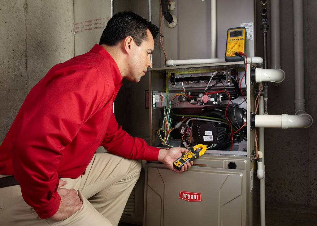 Heating and air conditioning technician servicing an indoor furnace in Clearfield, UT