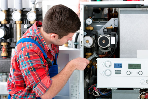HVAC technician inspecting an indoor heating system in Clearfield, UT