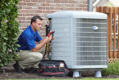 HVAC technician inspecting an outdoor air conditioning unit in Clearfield, UT